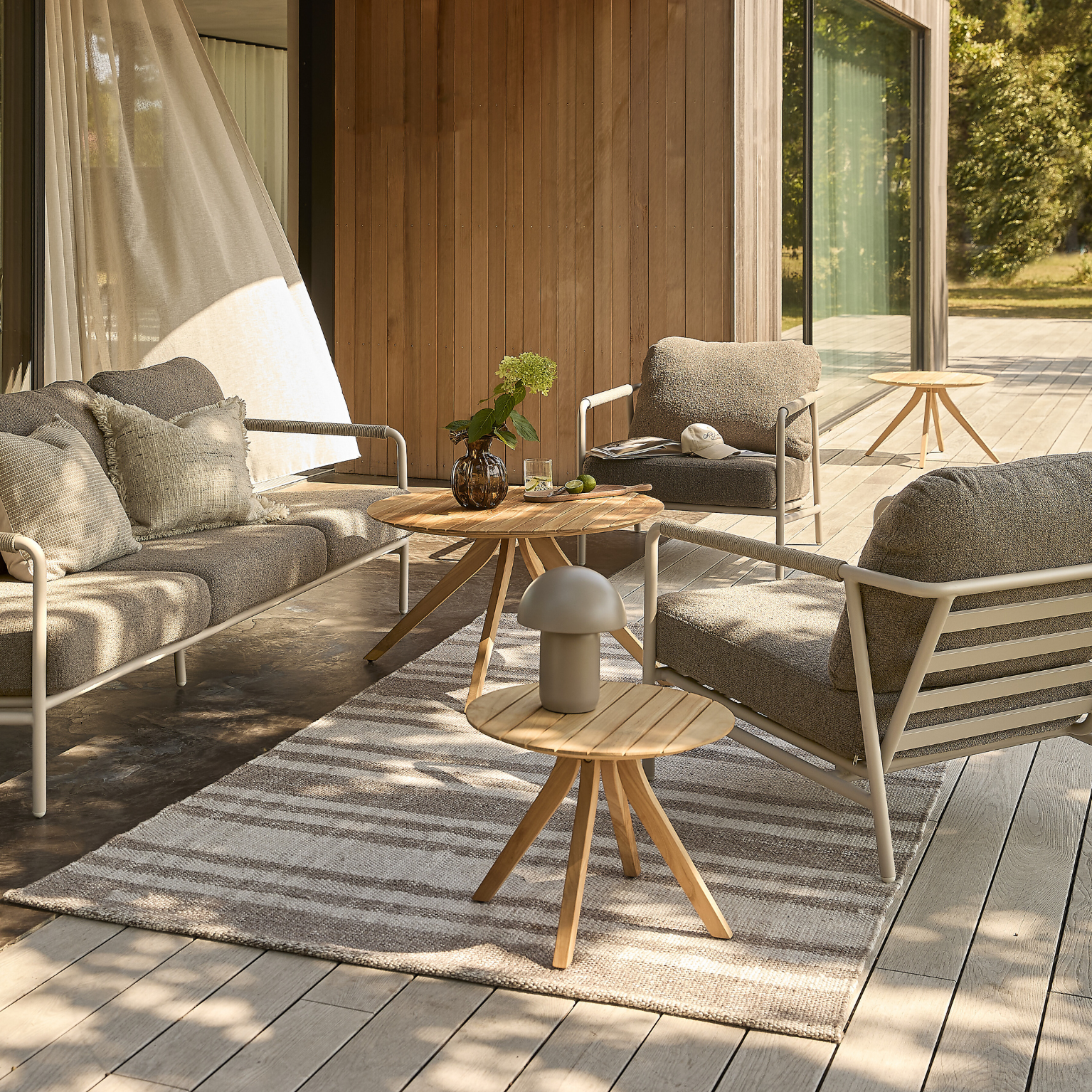 Loungeset med grå dynor på terrass.