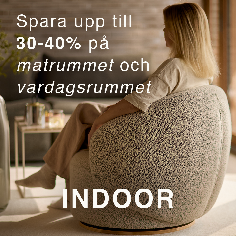 Kvinna sedd bakifrån som sitter i en grå fåtölj.