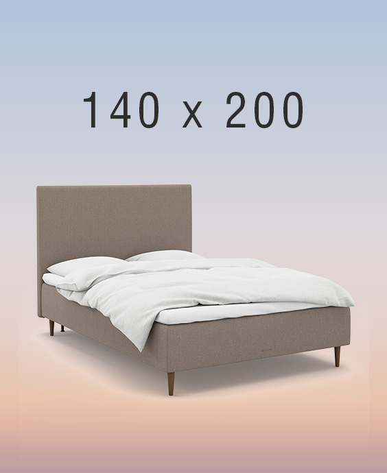 Ljusgrå kontinentalsäng i ett mysigt sovrum