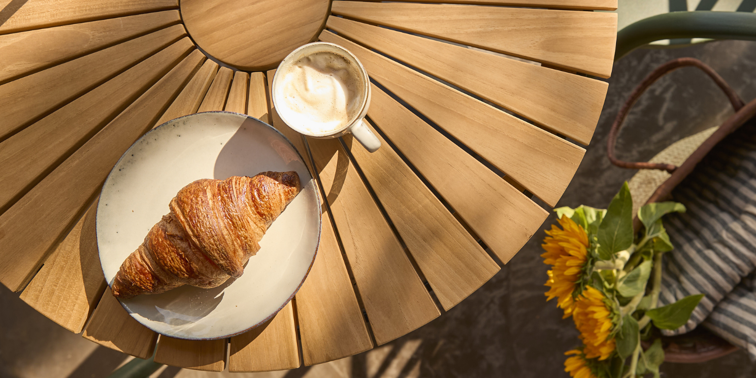 Nærbillede af rundt havebord i træ med lameller