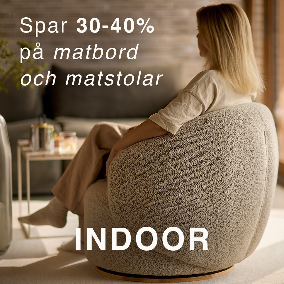 Kvinna sedd bakifrån som sitter i en grå fåtölj.