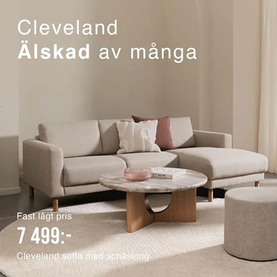 Beige soffa med schäslong i vardagsrummet.