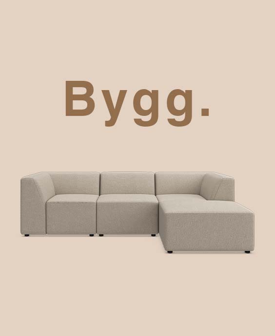 Grå modulsoffa mot beige bakgrund.