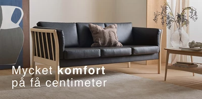 Klassisk pinnsoffa med svart läder i vardagsrummet.