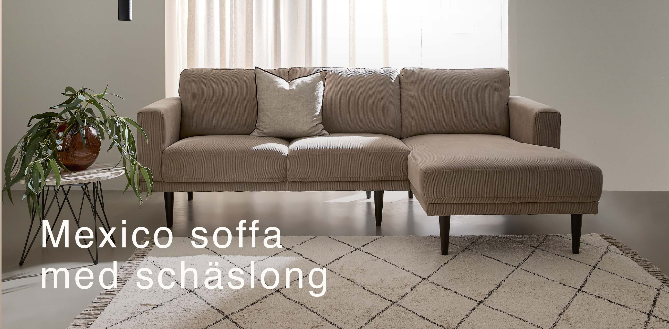 Beige schäslongsoffa i vardagsrummet.