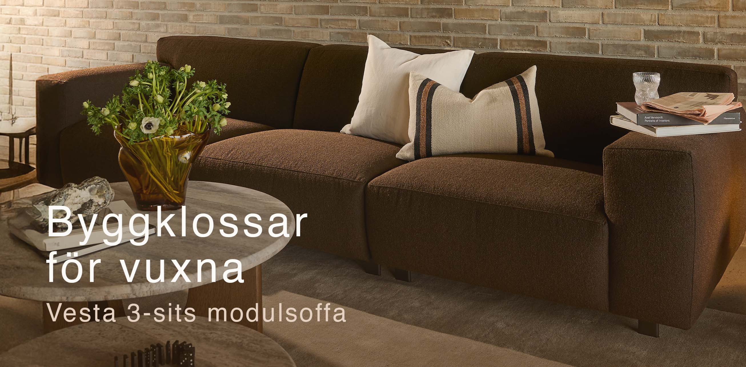 Brun modulsoffa framför tegelvägg