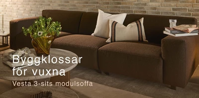 Brun modulsoffa framför tegelvägg
