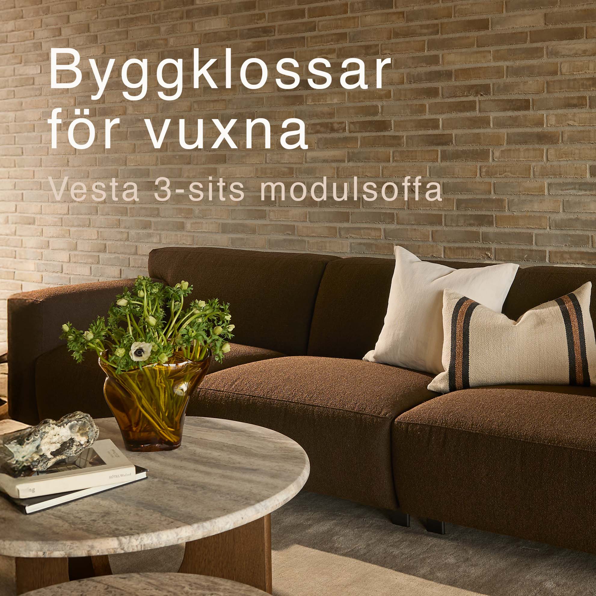 Brun modulsoffa framför tegelvägg