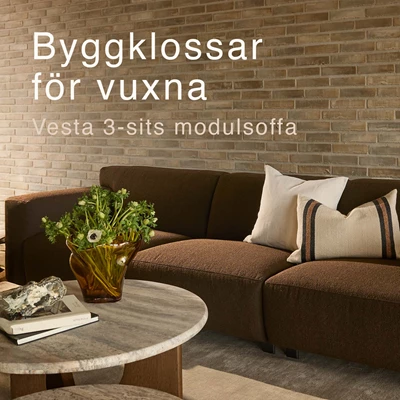 Brun modulsoffa framför tegelvägg