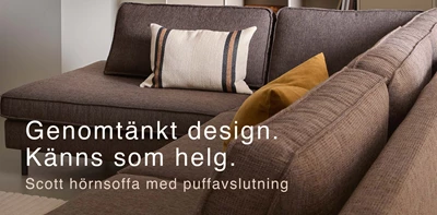 Grå soffa med två kuddar i orange nyanser.