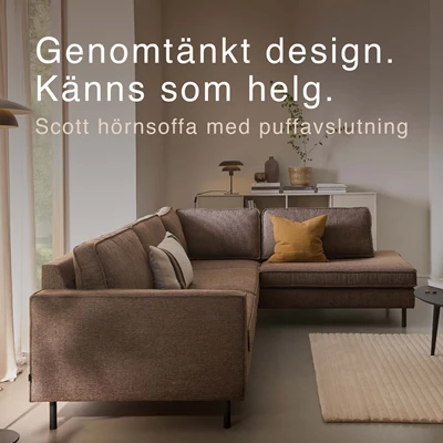 Grå soffa med två kuddar i orange nyanser.