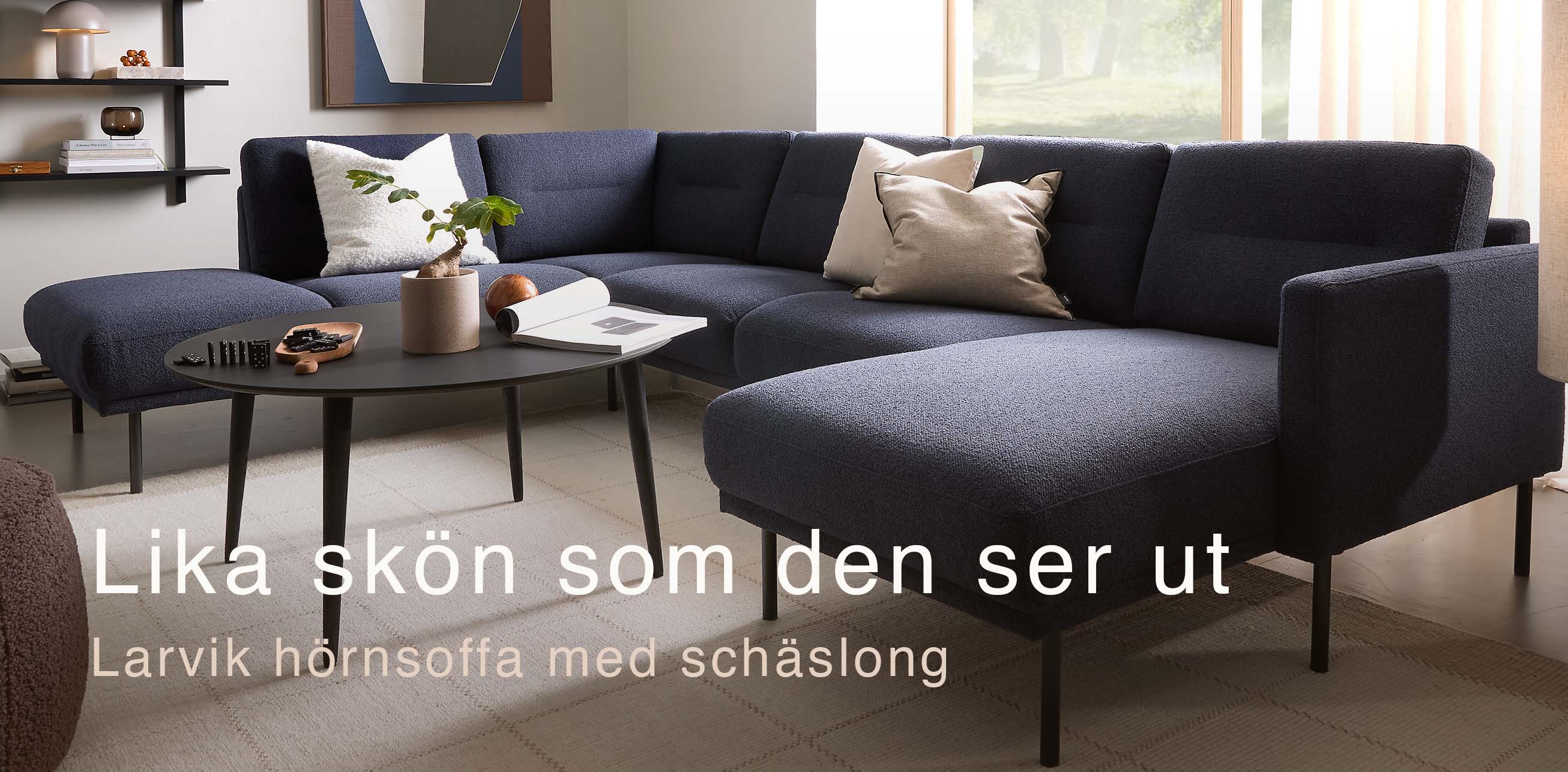Blåaktig U-soffa i ett mysigt vardagsrum med svart soffbord.