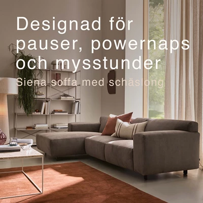 Gråaktig soffa med schäslong och röd matta.