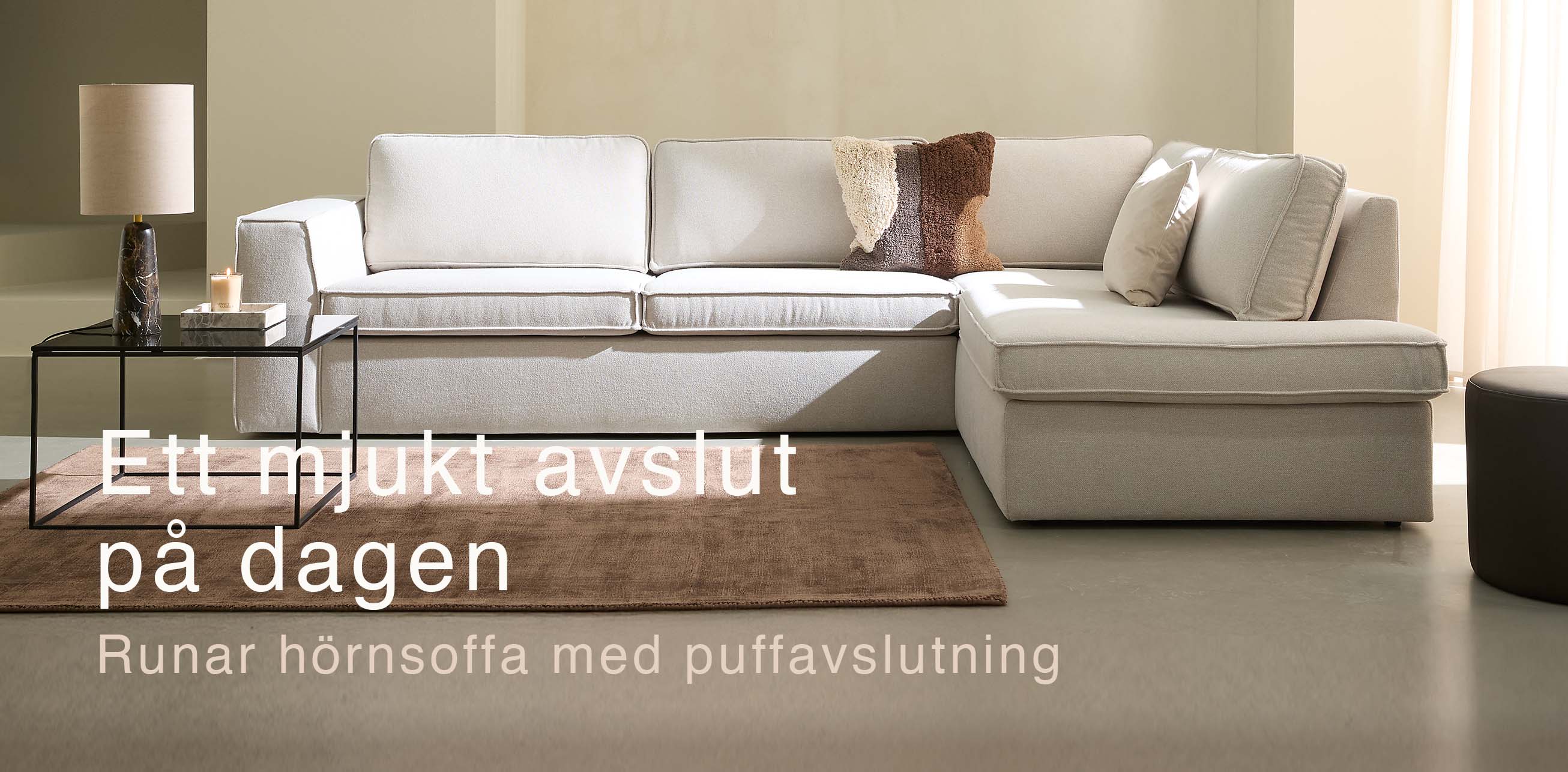 Vit soffa med puffavslutning.