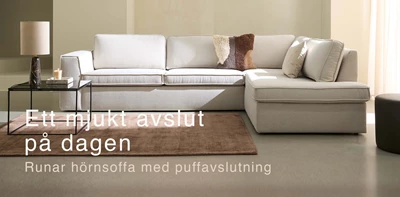 Vit soffa med puffavslutning.