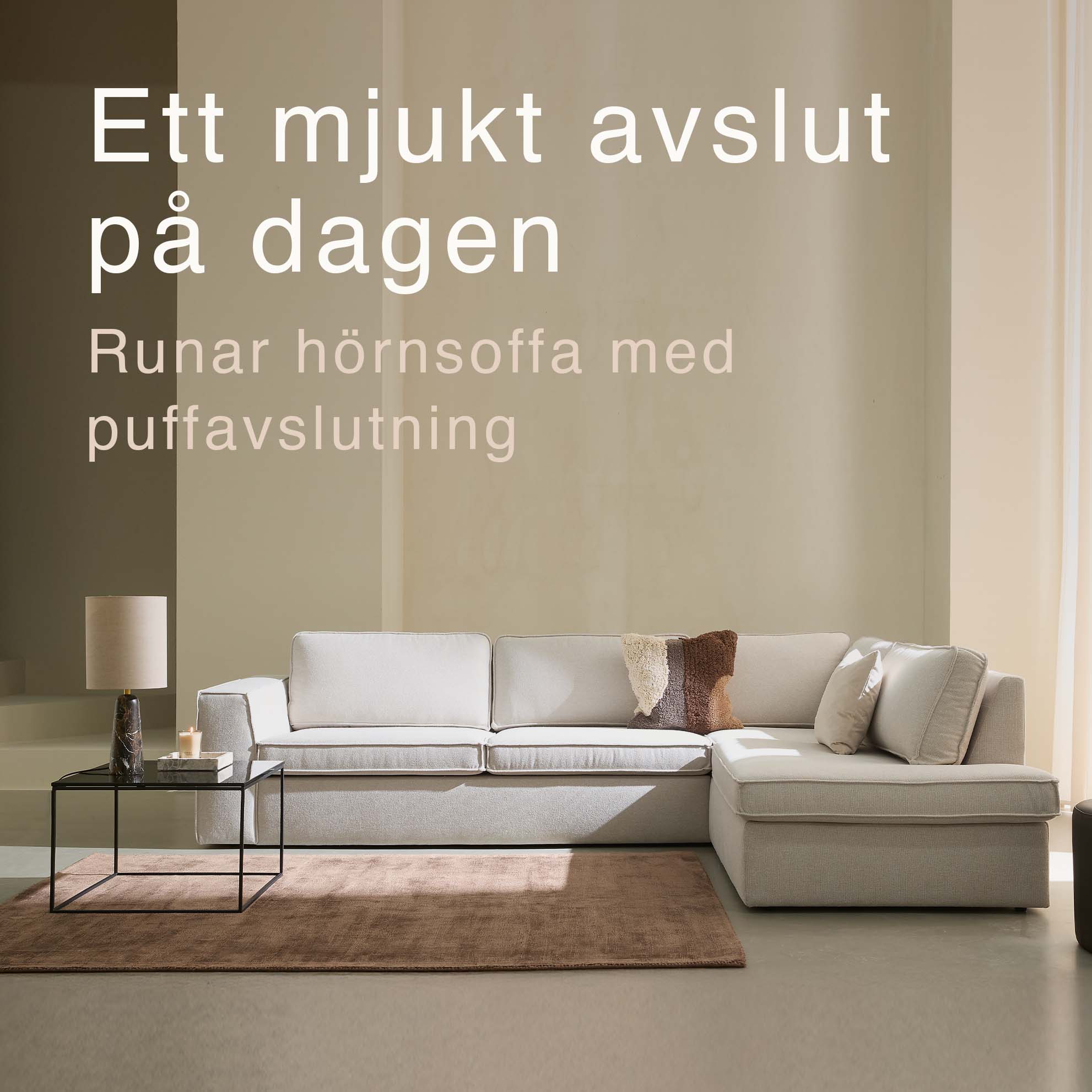 Vit soffa med puffavslutning.