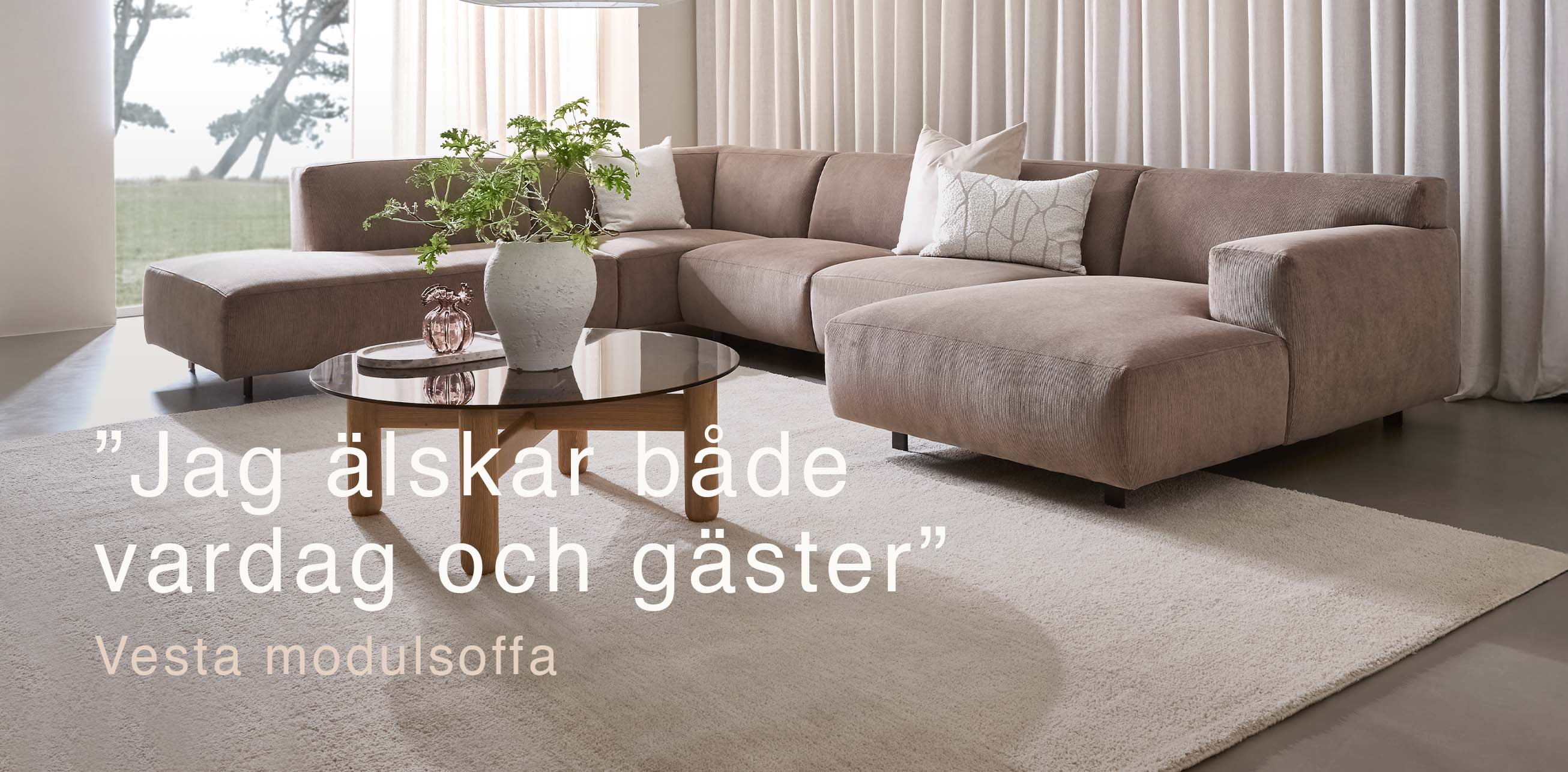 Beigefärgad U-soffa i vardagsrum med stort fönster.
