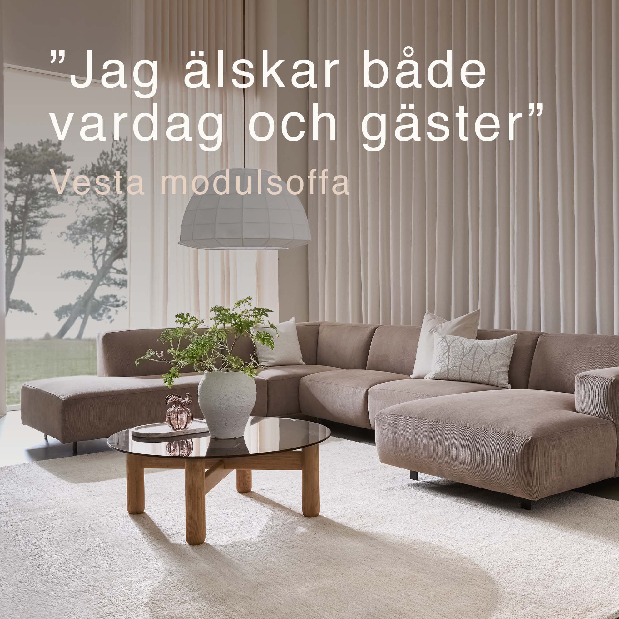 Beigefärgad U-soffa i vardagsrum med stort fönster.