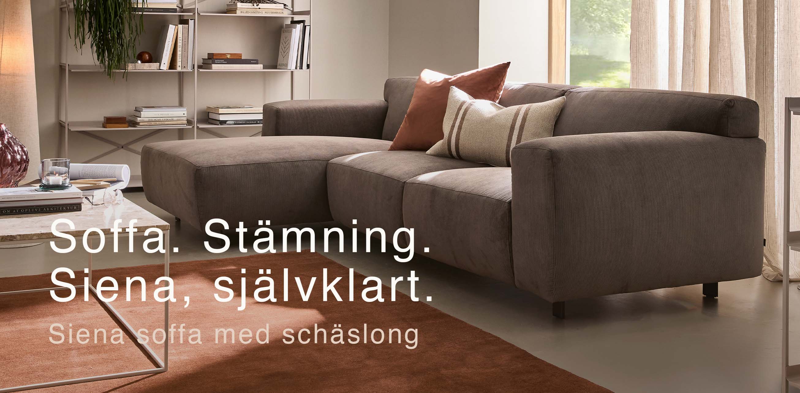 Soffa med schäslong framför röd matta.