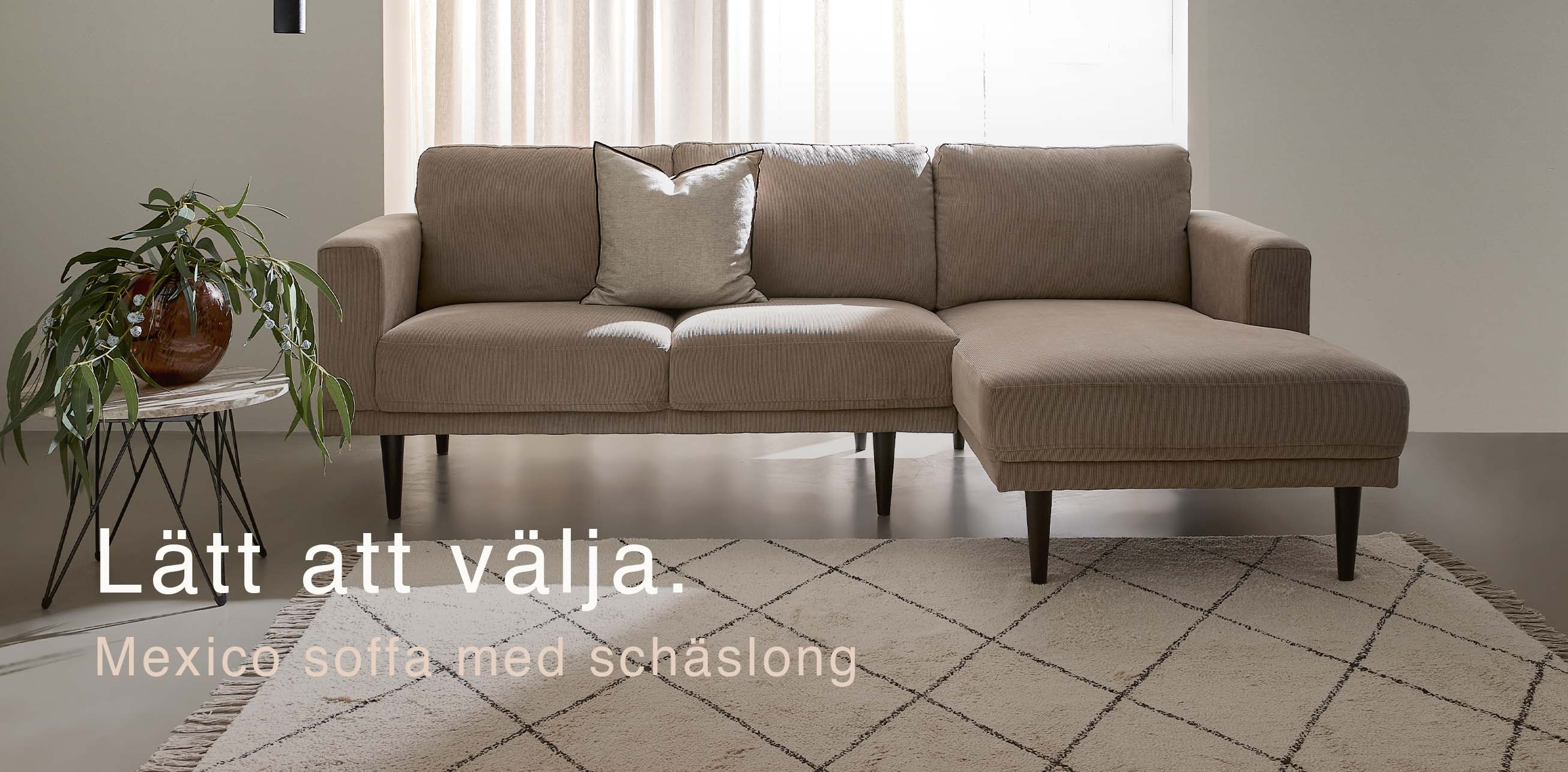 Klassisk soffa med schäslong i ett minimalistiskt vardagsrum.