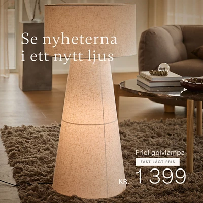 Beige golvlampa som står på en matta i vardagsrummet