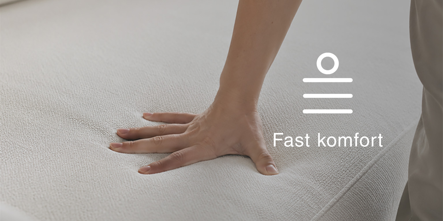 Närbild av en hand på en stoppad sittyta med text och ikon för fast komfort.