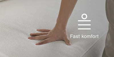 Närbild av en hand på en stoppad sittyta med text och ikon för fast komfort.