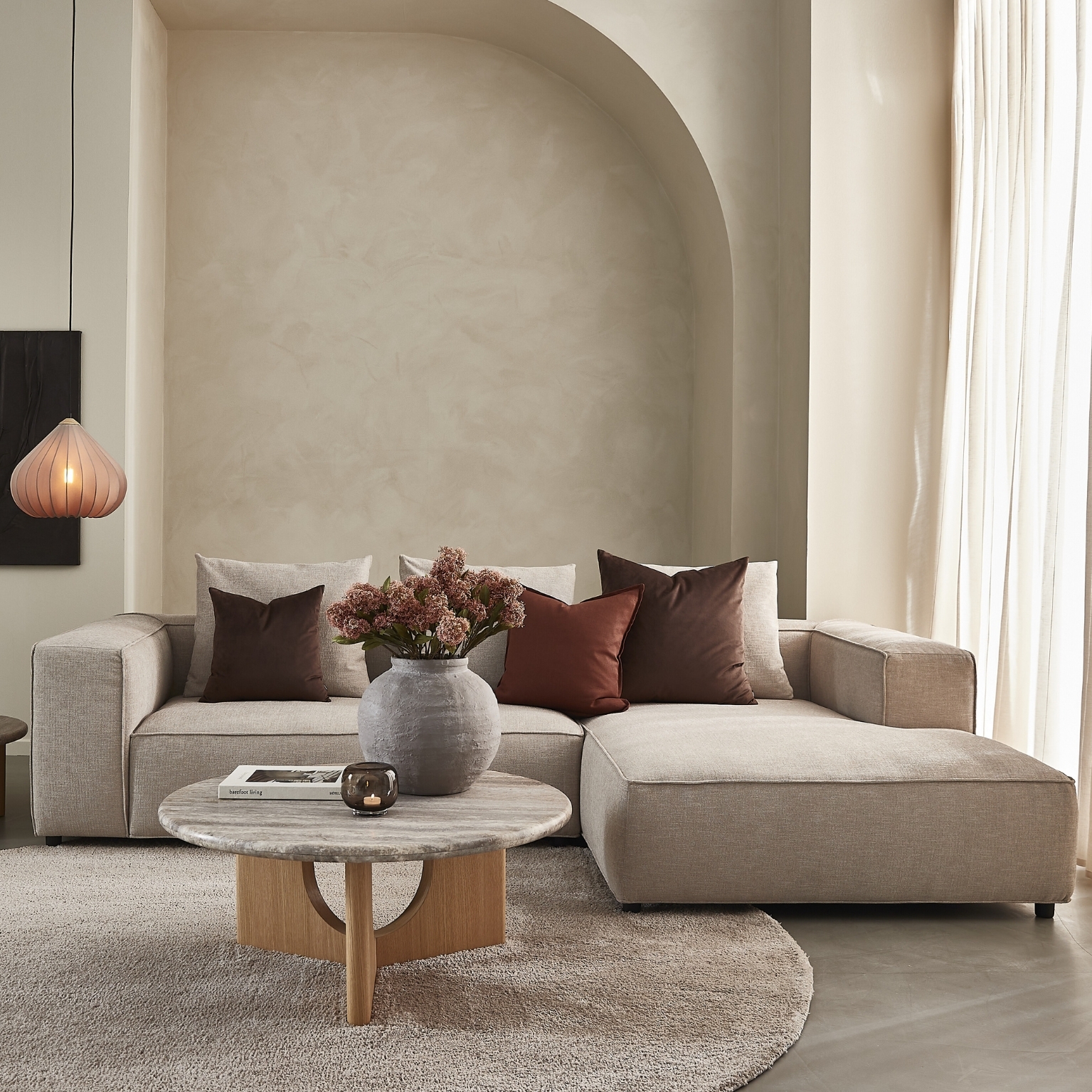 Nordstrom soffa i ljus klädsel med divan, kuddar och mjuka former i ett ljust vardagsrum
